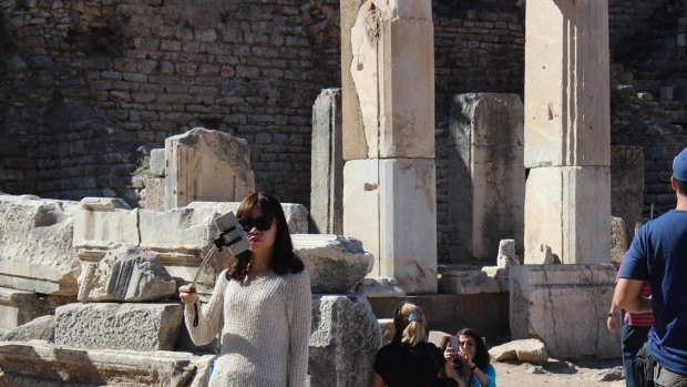 Tourists take selfies at Ephesus in Turkey.
