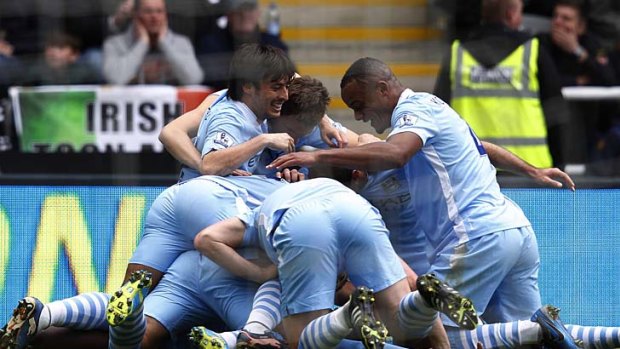 Manchester City players celebrate on top of Yaya Toure after he scored his first goal against Newcastle United last week.