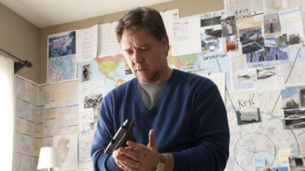How does this work?: A suburban school teacher (Russell Crowe) messes with a gun as he prepares to spring his wife from prison in the taut thriller The Next Three Days.
