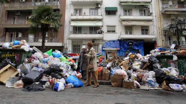 On the nose ... women navigate piles of rubbish in Thessaloniki after strikes by municipal workers over austerity measures.