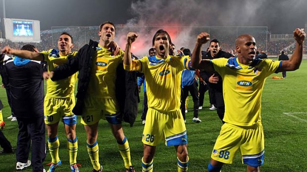 On the march: APOEL players celebrate after beating Lyon in the Champions League this month.