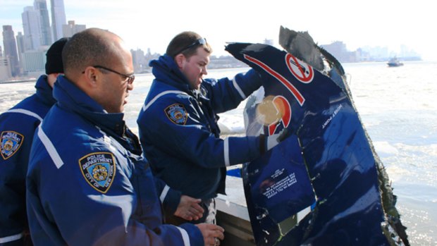 Police retrieve a piece of flight 1549 from the Hudson.