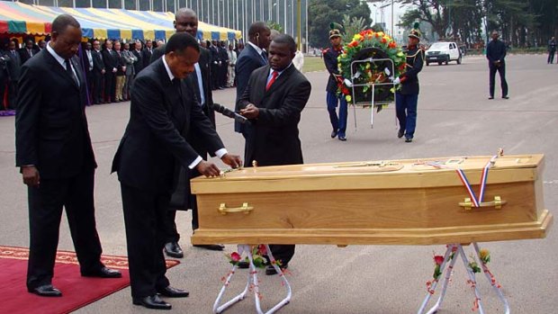 Congo President Denis Sassou Nguesso stands by the coffin of Australian mining tycoon Ken Talbot of Sundance Resources.