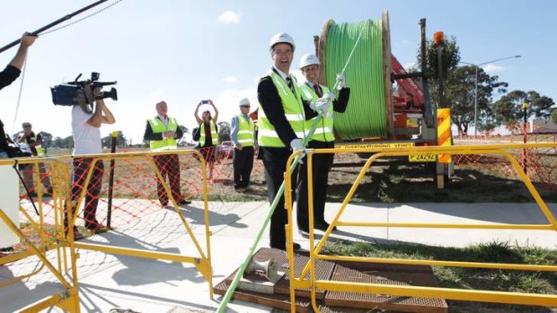 Communications Minister Stephen Conroy and Labor MP Andrew Leigh assist in laying the fibre optic cable for a photo opportunity, in the Canberra suburb of Gungahlin.