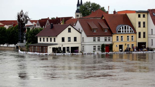 Residants watch the high tide scale of the river Elbe in Schoenebeck, eastern Germany, on June 9, 2013. Flood waters rose in eastern Germany Saturday, forcing the evacuation of homes and a hospital, as Hungary propped up its defences against central Europe's worst floods in a decade.