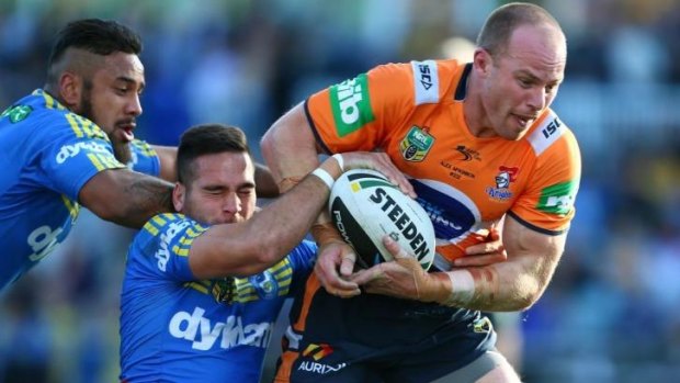Gritty match: Eels players tackle  Beau Scott of the Knights.