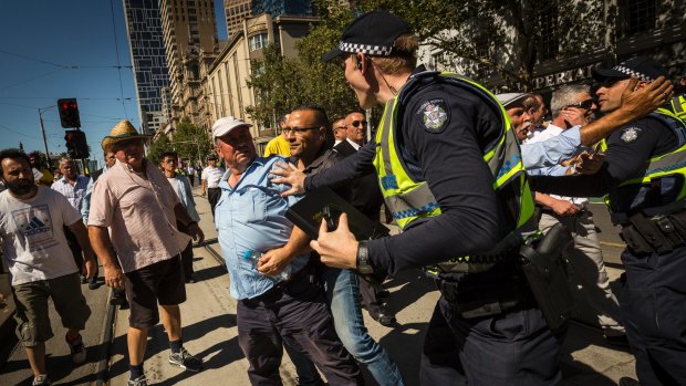 Taxi drivers are seen remonstrating with police during a protest outside State Parliament
