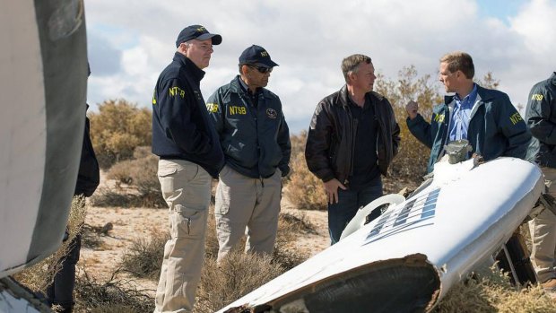 Virgin Galactic pilot Todd Ericson, right, talks with National Transportation Safety Board, Acting Chairman Christopher A. Hart, second from left, at the SpaceShipTwo accident site with investigators in Mojave, California.