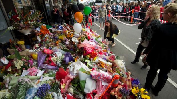 Thousands of people walk along Sydney Road in a peace march after the murder of Jill Meagher. Flowers left at the Duchess Boutique where Jill was caught on CCTV.
