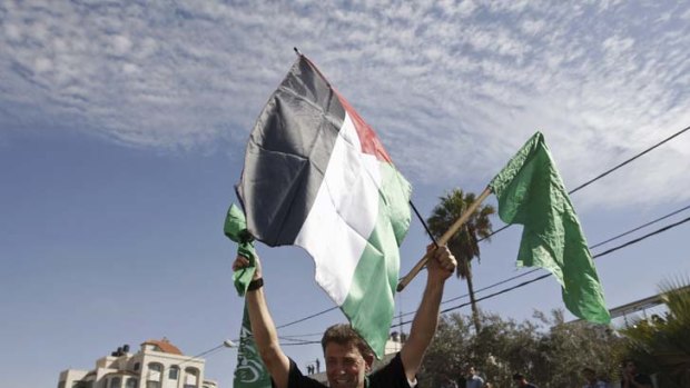 Released prisoner Hamas militant Nael Barghouti waves a green Islamic flag and a Palestinian flag.