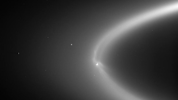 As Enceladus orbits Saturn, it leaves a trail of particles from its geysers in its wake, forming Saturn's 'E ring'. (NASA/JPL/Space Science Institute)