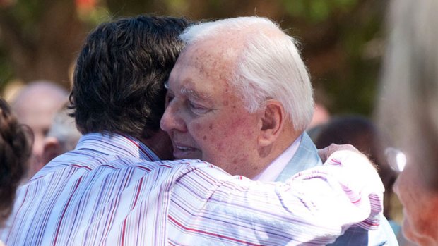 Alan Bond is comforted by a friend at wife, Diana Bliss' funeral.