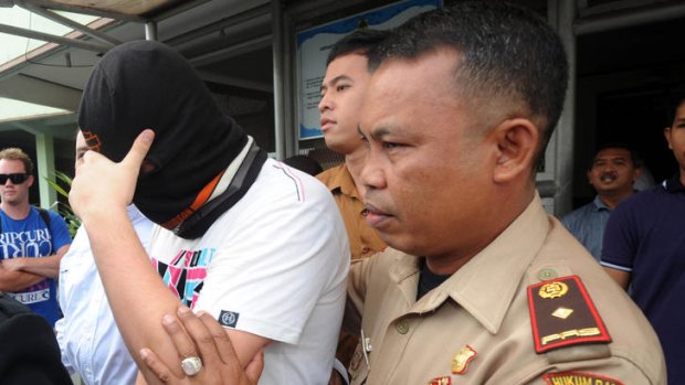 Homeward bound: The freed teen covers his face as he leaves Kerobokan prison in Denpasar.