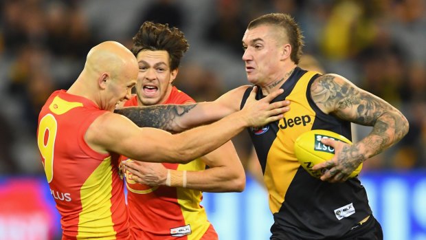 Don't argue: Richmond's Dustin Martin fends off Gold Coast skipper Gary Ablett.