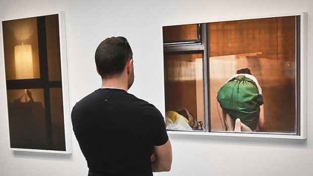 A visitor views the photography of Arne Svenson at the Julie Saul Gallery in New York.