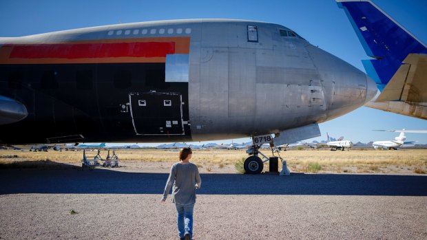 Brandi Lange, an operations manager for Logistic Air, walks to a cargo Boeing 747 her company helps maintain at Pinal Airpark.