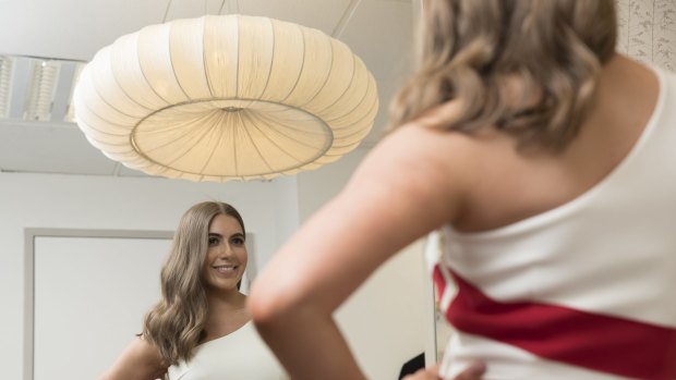 Brittany Farinola, 20, tries on a designer dress at the Myer store in Adelaide before her trip to Sydney for this week's spring/summer launch parade.