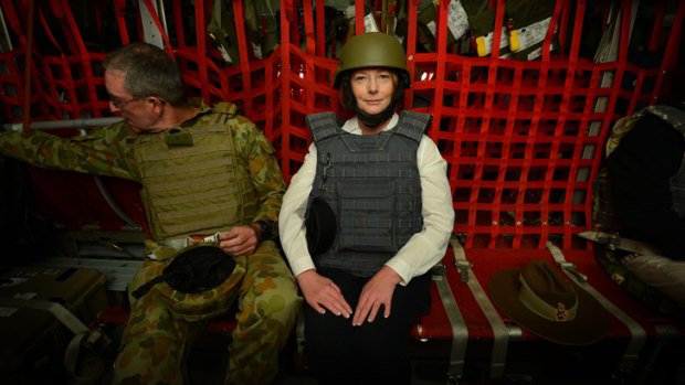 Prime Minister Julia Gillard wears a helmet and body armour beside Lieutenant-General Powell before take-off in a RAAF Hercules C-31 from Kabul.