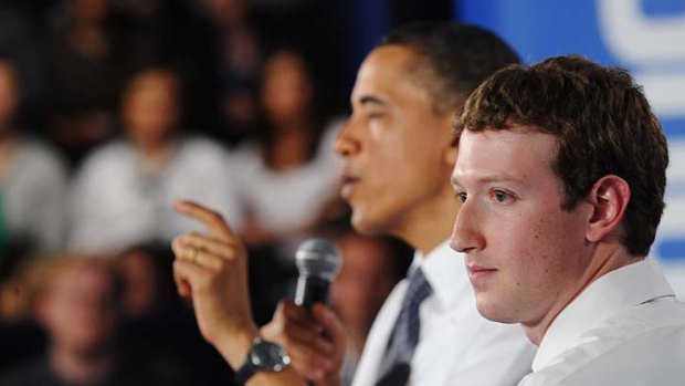 Barack Obama speaks as Facebook CEO Mark Zuckerberg looks on.