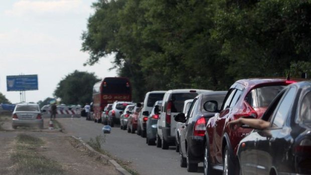 Cars queue at a checkpoint as people flee the southern Ukrainian city of Mariupol amid fears of an attack by pro-Russian militants.