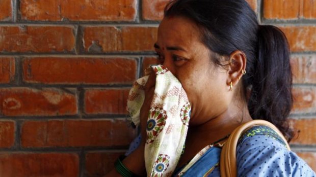 A Nepalese woman cries as a relative injured in the mudslide is treated at a hospital in Katmandu.