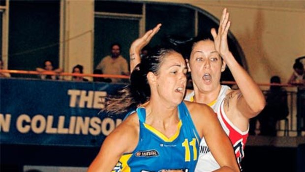 Jenna O’Hea pushes past Tegan Cunningham during last night’s WNBL match at Bulleen.