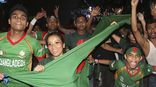 Bangladeshis celebrate on the street after their team's victory over England.