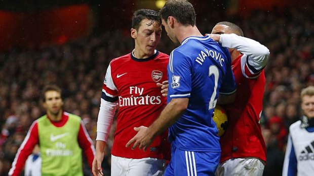 Arsenal's Mesut Ozil (2nd L) clashes with Chelsea's Branislav Ivanovic (2nd R).