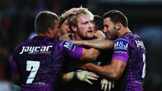 Purple patch: James Graham is mobbed by Bulldogs teammates after scoring a try against the Warriors.