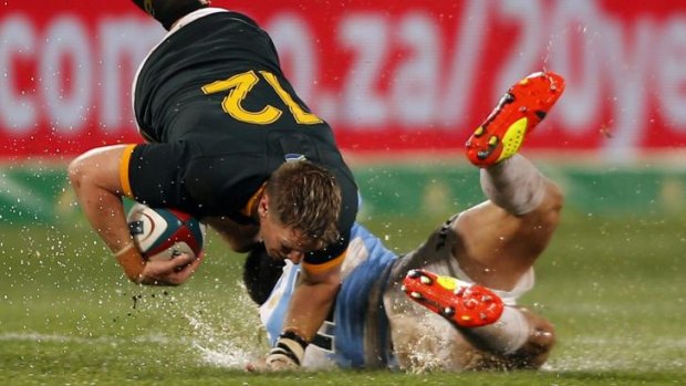 Desperate measures: South African captain Jean de Villiers is tackled by Argentina's Juan Martin.