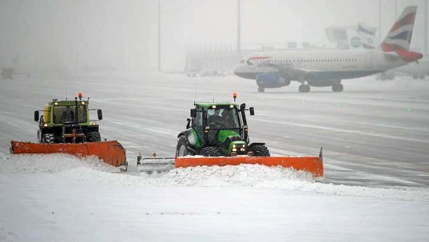 Snow ploughs clean the tarmac at Munich airport.