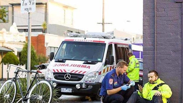Indigo Wood being attended to by a paramedic after his hair-raising encounter with a car in Collingwood on Friday. He was lucky to escape with nothing worse than swollen knees and a smashed helmet.