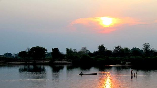 Sunset in Don Det ... enthusiasts opt to swim out to a sandbar marked with a solitary branch planted by travellers past.