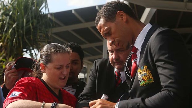 Rio Ferdinand signs autographs for fans at Sydney airport.