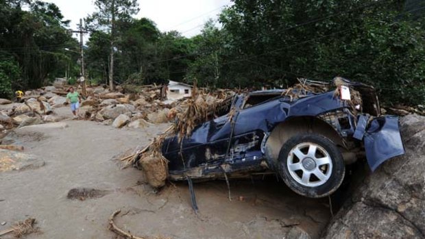 A destroyed car is seen in the main street of Teresopolis' Campo Grande neighbourhood.