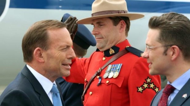 Tony Abbott, left, is greeted by Pierre Poilievre, a Canadian minister, at Ottawa airport.