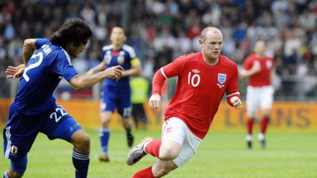 England's Wayne Rooney and Japan's Yuji Nakazawa challenge for the ball.