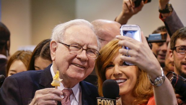 Berkshire Hathaway chairman and CEO Warren Buffett, holds an ice cream as he poses for a selfie with Liz Claman of the Fox Business Network during the annual Berkshire Hathaway shareholders meeting in Omaha, Nebraska.