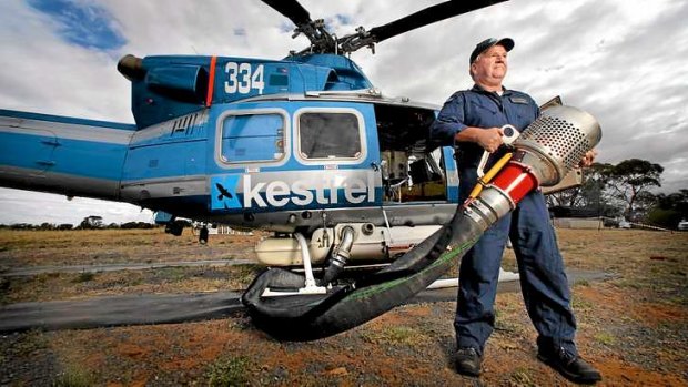 Kestrel Aviation pilot David Sewell shows his helicopter's fire fighting hardware.
