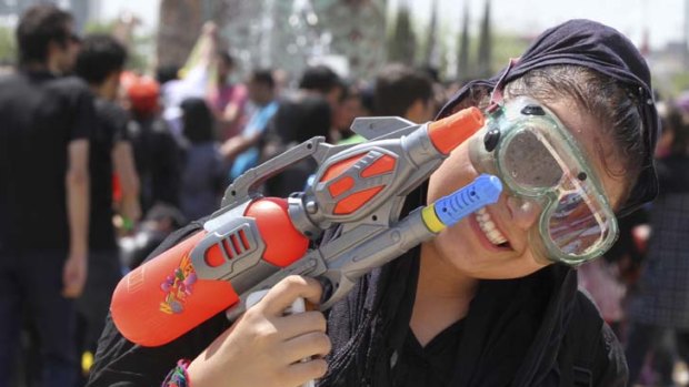 A young Iranian woman poses with her water gun.