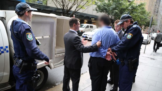 Police lead the 34-year-old lawyer from his Martin Place office.