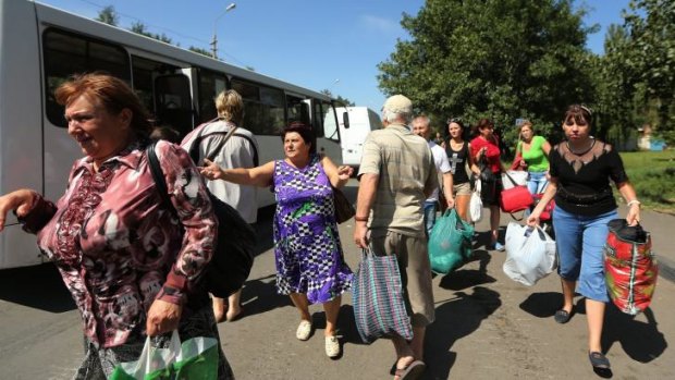 Residents of Shakhtersk run towards buses being provided by the pro-Russian rebels for people wanting to flee the town from the conflict after heavy shelling over the past two days in the area.