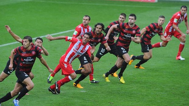 On the run: Western Sydney and Heart players all have eyes on the ball on Saturday night.