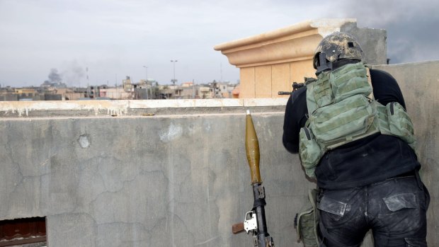 An Iraqi soldier watches enemy movements on the front line in  Ramadi.