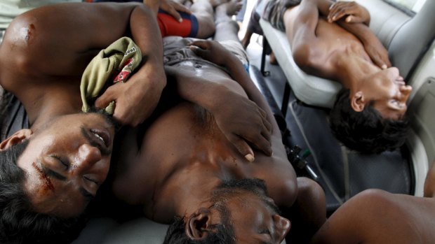 Ill migrants who arrived by boat with Rohingya and Bangladeshi migrants wait inside an ambulance for transport to a local hospital in Kuala Langsa in Indonesia's Aceh Province.
