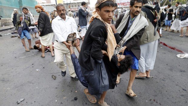 A wounded man is carried from the scene of the attack in Sanaa.