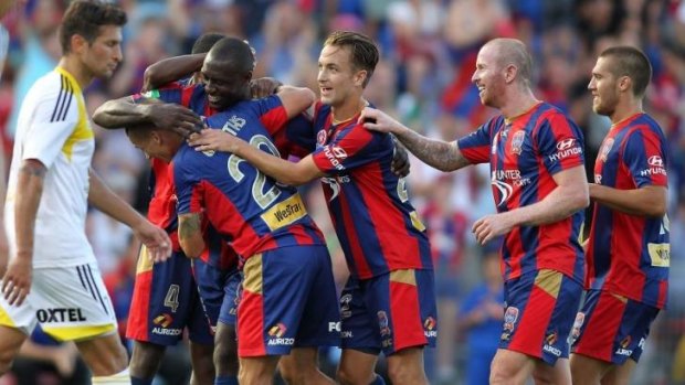 Congratulation time: Scorer Emile Heskey is mobbed by his Newcastle Jets teammates. 