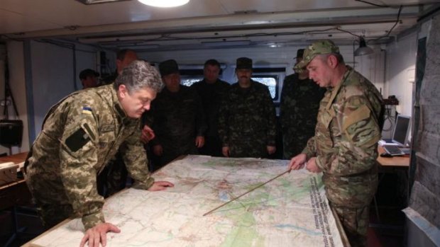Planning peace: Ukrainian President Petro Poroshenko, left, examines a map at a military base close to Slovyansk, in the Donetsk region.