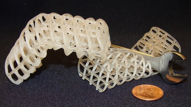 Two 3D-printed soft, flexible scaffolds: the one on the left is maintained in a rigid, bent position via a cooled, rigid wax coating, while the one on the right is uncoated and remains compliant (here, it collapses under a wrench).