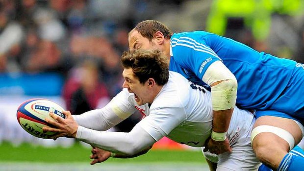 England's fullback Alex Goode is tackled by Sergio Parisse.